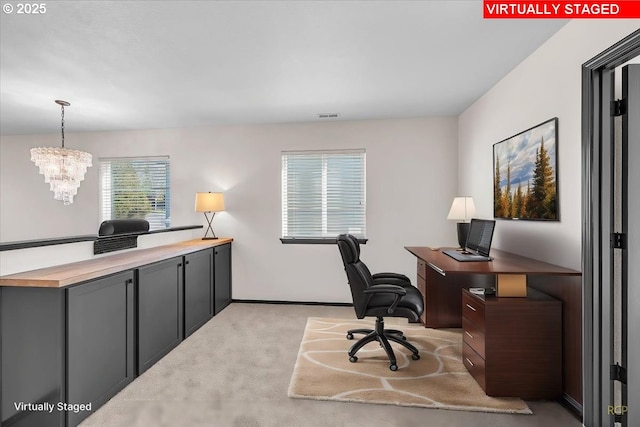 office with light carpet, visible vents, and a chandelier