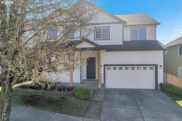 view of front of property with an attached garage, roof with shingles, and driveway