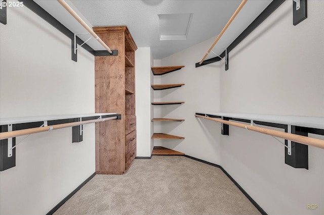 spacious closet featuring light colored carpet and attic access