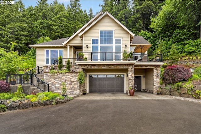 10448 SE 147th Ave, Happy Valley, OR 97086 - rustic home with a balcony, stone siding, driveway, an attached garage, and stairs