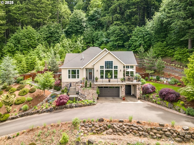10448 SE 147th Ave, Happy Valley, OR 97086 - view of front of home featuring stairway, stone siding, asphalt driveway, a garage, and a forest view