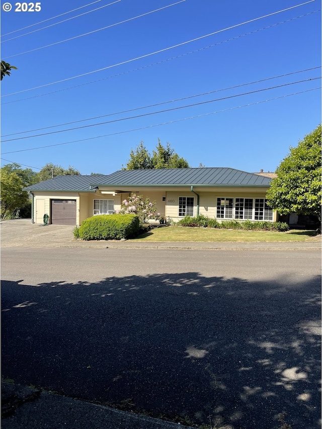 460 N 20th St, Reedsport, OR 97467 - view of front of house with an attached garage, a standing seam roof, and metal roof