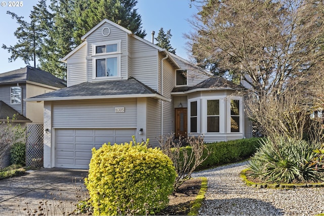 traditional home with a garage, concrete driveway, and a shingled roof