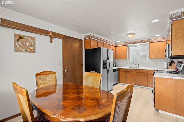 4775 Sienna Dr NE, Salem, OR 97301 - kitchen featuring appliances with stainless steel finishes, brown cabinetry, light countertops, a textured ceiling, and recessed lighting