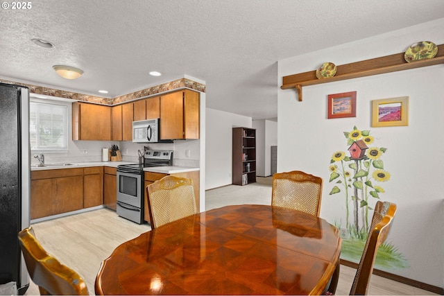 4775 Sienna Dr NE, Salem, OR 97301 - kitchen with stainless steel appliances, brown cabinetry, light countertops, and a textured ceiling