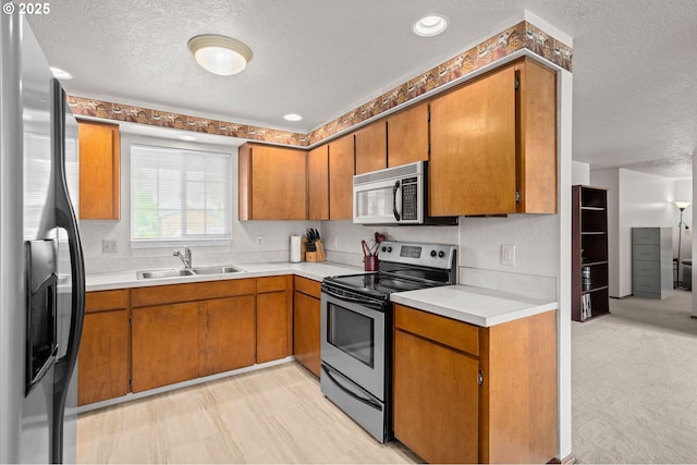 4775 Sienna Dr NE, Salem, OR 97301 - kitchen with appliances with stainless steel finishes, a textured ceiling, brown cabinets, and light countertops