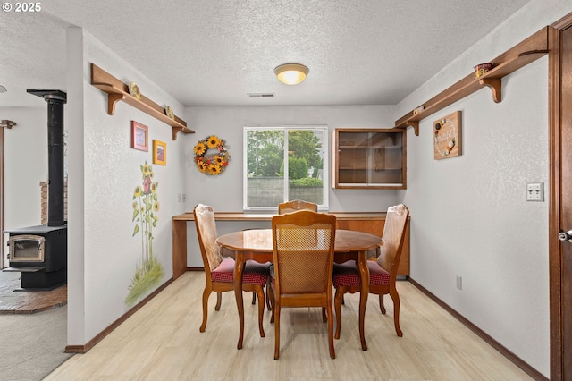 4775 Sienna Dr NE, Salem, OR 97301 - dining room with a textured ceiling, light wood-style floors, and a wood stove