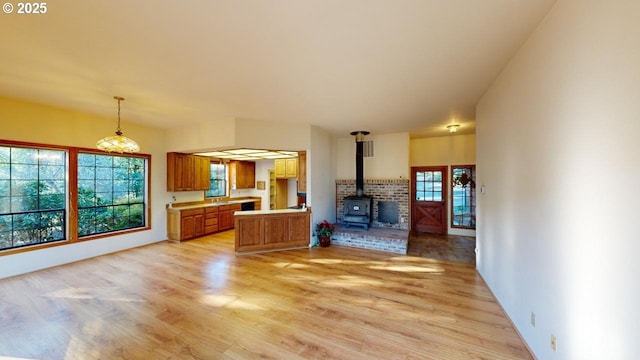 unfurnished living room featuring light hardwood / wood-style floors and a wood stove