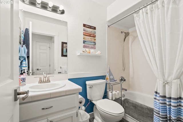 full bathroom featuring toilet, a textured wall, shower / bath combination with curtain, and vanity