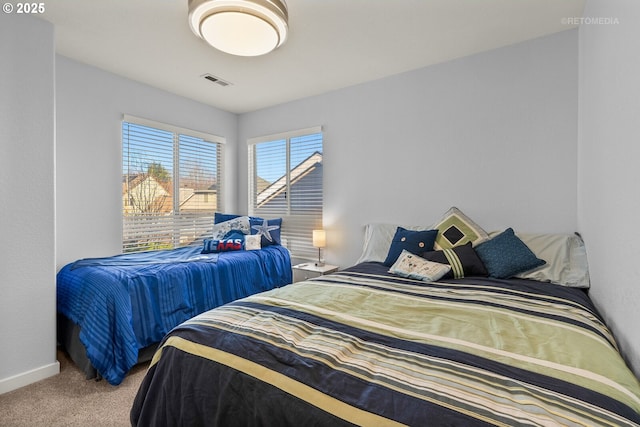 carpeted bedroom featuring visible vents and baseboards