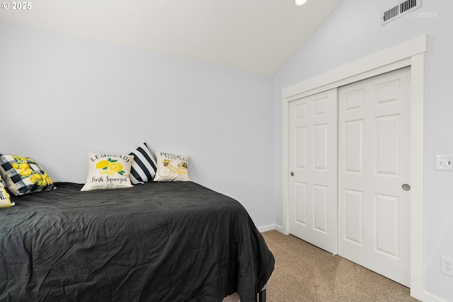 bedroom with lofted ceiling, carpet floors, a closet, and visible vents