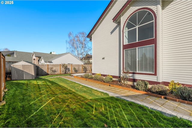 view of yard with a storage shed, an outdoor structure, and a fenced backyard