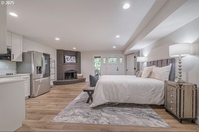 3175 Glen Creek Rd, Salem, OR 97304 - bedroom featuring stainless steel fridge with ice dispenser, light wood-style flooring, recessed lighting, and a brick fireplace