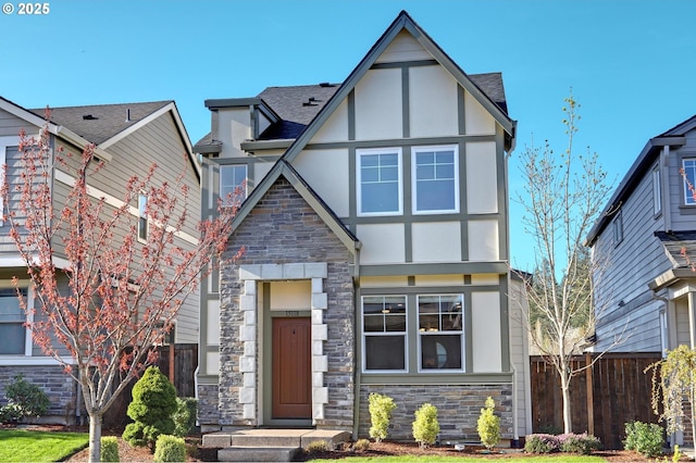 tudor house featuring stucco siding, stone siding, and fence