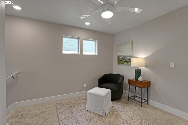 sitting room with carpet flooring, baseboards, and ceiling fan