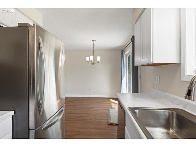kitchen featuring a sink, appliances with stainless steel finishes, white cabinets, and dark wood-style floors