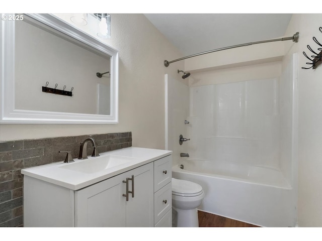 bathroom with vanity, wood finished floors, bathing tub / shower combination, and toilet