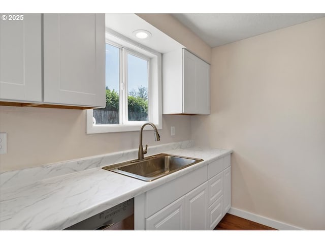 kitchen featuring a sink, wood finished floors, white cabinetry, and dishwasher