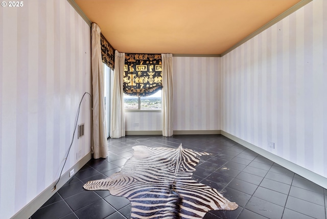 empty room featuring wallpapered walls and dark tile patterned flooring