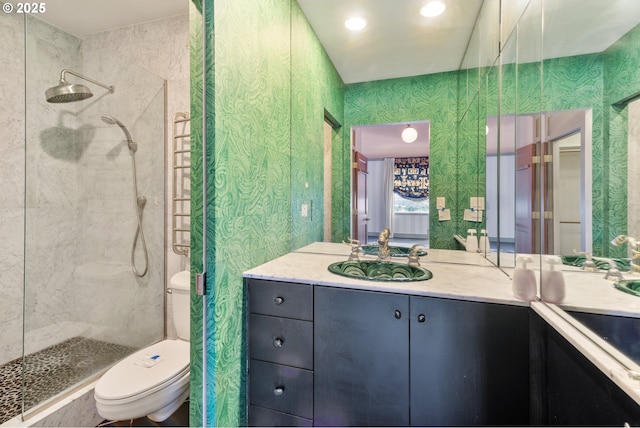 full bathroom featuring toilet, tiled shower, and vanity