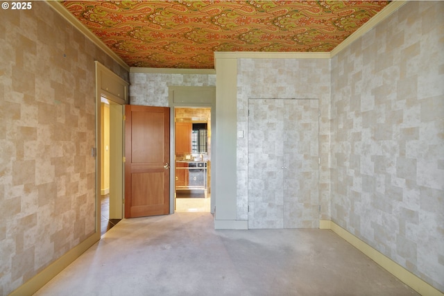 unfurnished room with crown molding, wallpapered walls, baseboards, and an ornate ceiling