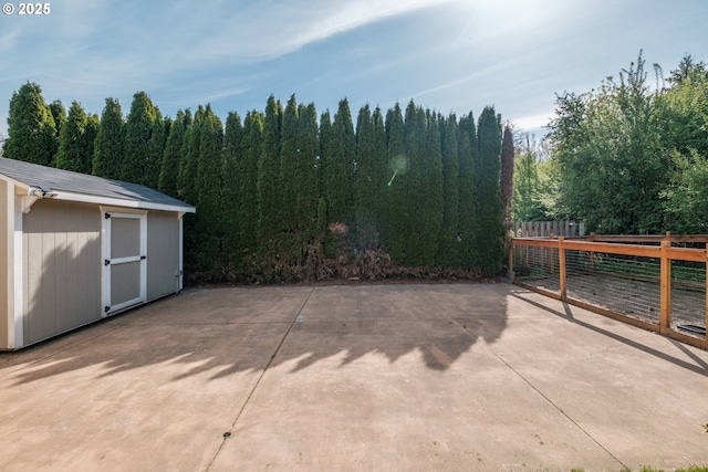 view of patio / terrace featuring fence, a storage unit, and an outdoor structure