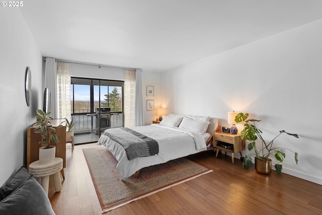 bedroom with wood finished floors and access to outside