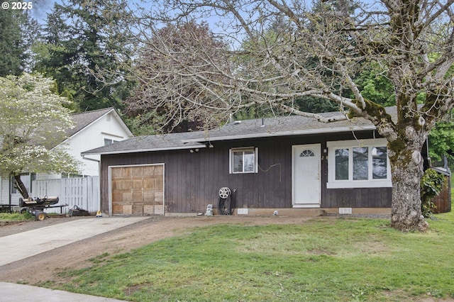 view of front facade featuring fence, concrete driveway, an attached garage, and a front lawn