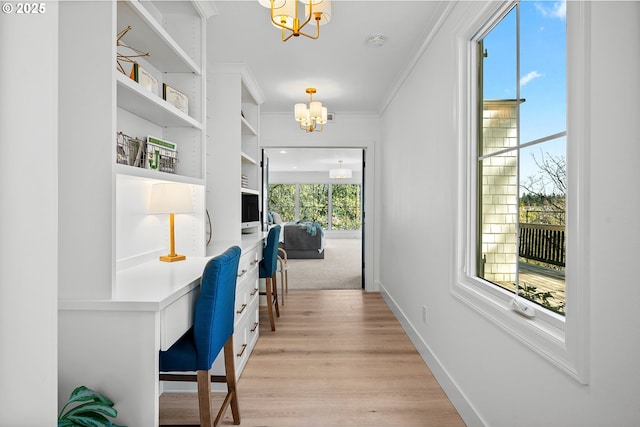 corridor featuring a chandelier, ornamental molding, light wood finished floors, baseboards, and an office area