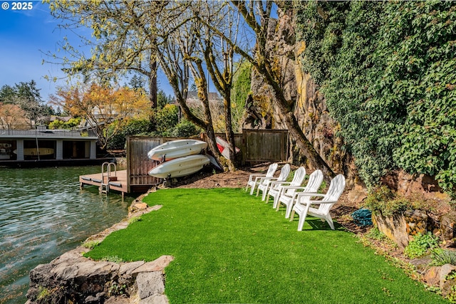 view of yard with a boat dock and a water view