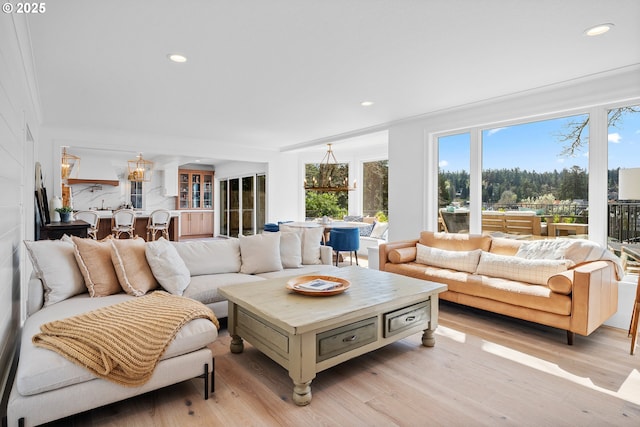 living room featuring light wood-style flooring, recessed lighting, and a chandelier