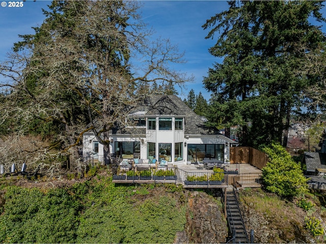 back of house with a balcony, a fenced backyard, and outdoor lounge area