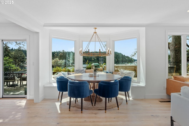 dining room featuring ornamental molding, a chandelier, wood finished floors, and baseboards