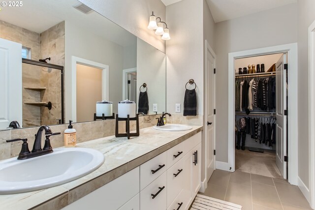 bathroom featuring vanity, a shower with shower door, and tile patterned floors