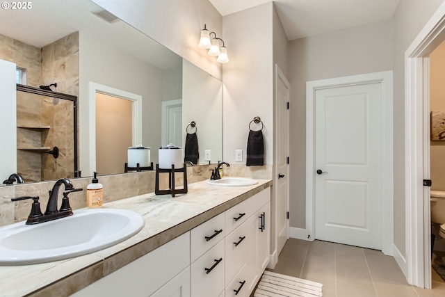 bathroom with vanity, tile patterned floors, toilet, and walk in shower