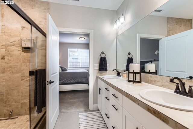 bathroom featuring walk in shower, vanity, and tile patterned flooring