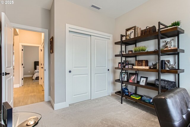 sitting room featuring light carpet