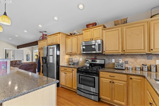 238 SW 27th St, Newport, OR 97365 - kitchen with stainless steel appliances, lofted ceiling, light wood finished floors, backsplash, and dark stone countertops