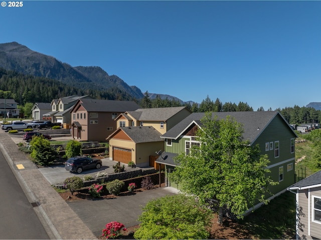 exterior space featuring a mountain view, driveway, a residential view, and board and batten siding