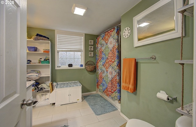 bathroom with a shower with curtain, tile patterned floors, and toilet