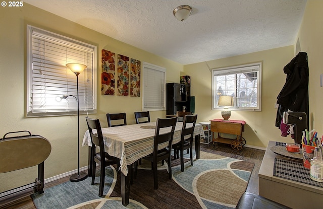 dining space featuring dark wood-type flooring and a textured ceiling