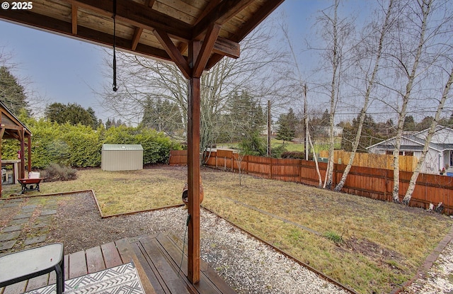 view of yard featuring a storage unit and a deck