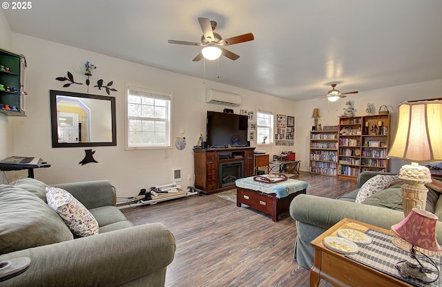 living room featuring hardwood / wood-style flooring, ceiling fan, and a wall unit AC