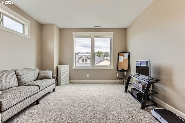 carpeted living room featuring baseboards