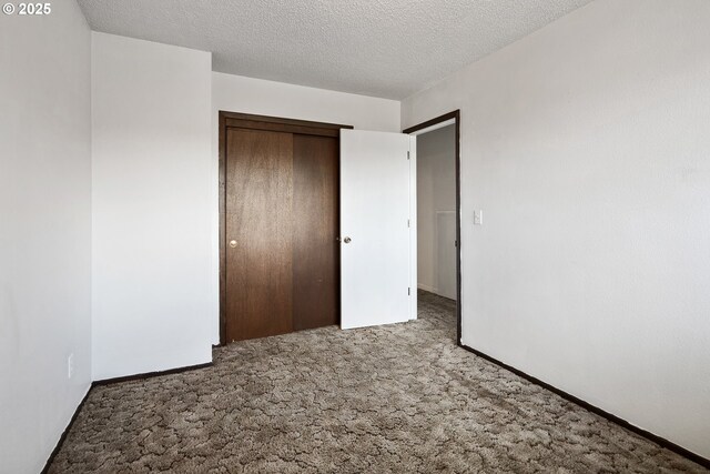 11613 Pacific Ct NE, Woodburn, OR 97071 - unfurnished bedroom with carpet flooring, a closet, and a textured ceiling