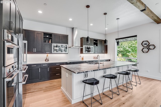 634 NE Province Ct, Camas, WA 98607 - kitchen featuring wall chimney range hood, a sink, double oven, open shelves, and backsplash