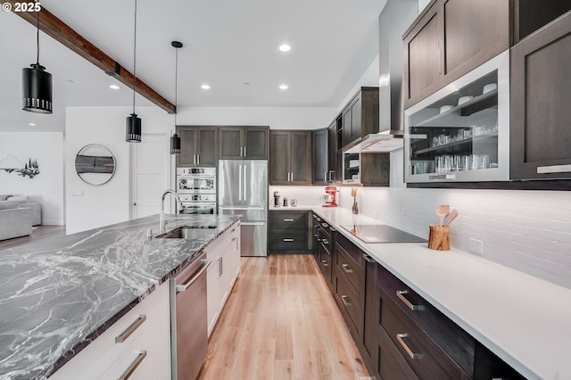 634 NE Province Ct, Camas, WA 98607 - kitchen with appliances with stainless steel finishes, decorative backsplash, wall chimney exhaust hood, light wood-style floors, and dark brown cabinets
