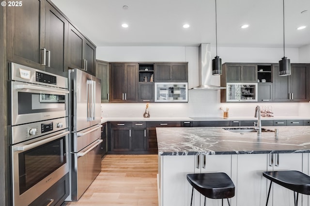 634 NE Province Ct, Camas, WA 98607 - kitchen featuring open shelves, appliances with stainless steel finishes, wall chimney exhaust hood, a kitchen bar, and dark stone counters