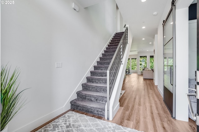 634 NE Province Ct, Camas, WA 98607 - staircase featuring a barn door, wood finished floors, recessed lighting, and baseboards