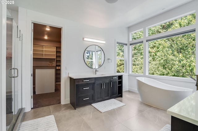 634 NE Province Ct, Camas, WA 98607 - bathroom with vanity, a stall shower, a walk in closet, a soaking tub, and tile patterned flooring